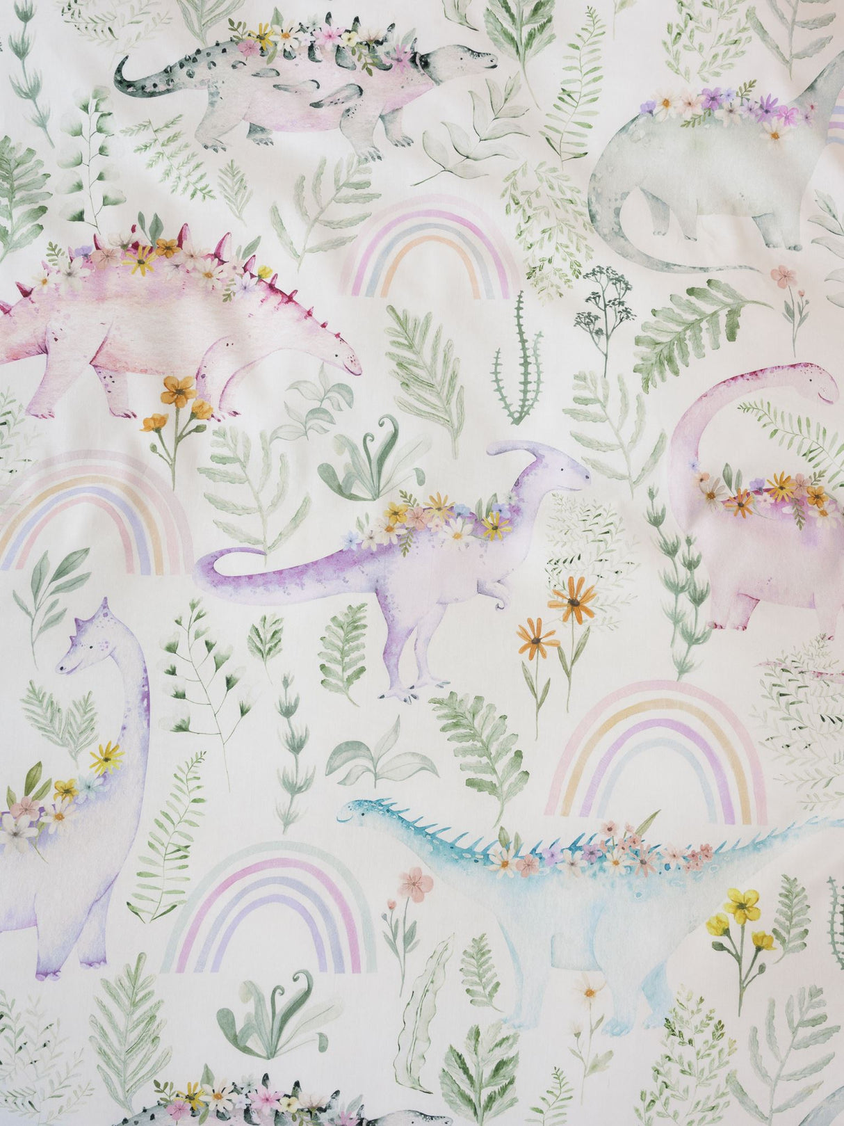 Dino Garden Duvet Cover Set featuring pastel dinosaurs among flowers and rainbows, made from soft 100% cotton for kids' beds.