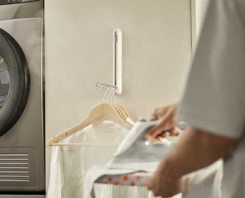 Orderly Retractable Hanging Rail by Joseph Joseph, a space-saving solution for drying and ironing clothes, mounts easily on walls or doors.