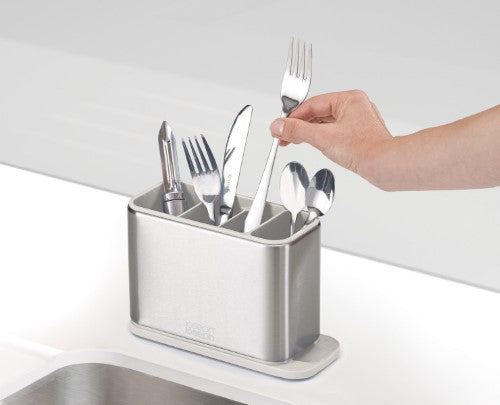 Stainless steel cutlery drainer with divided compartments and integrated spout for efficient drying and organization.