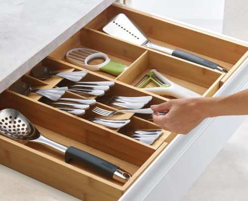 Bamboo drawer organiser with five cutlery compartments and two gadget sections for efficient kitchen storage.