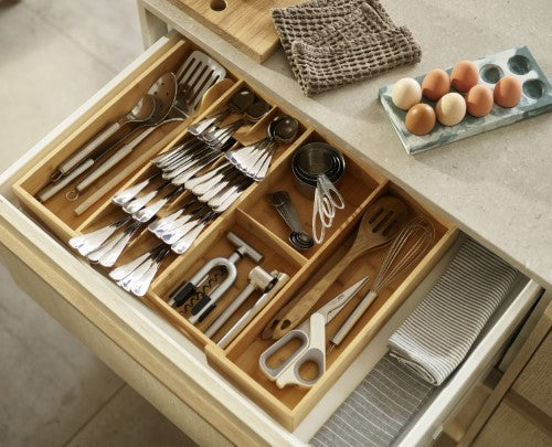 Bamboo drawer organiser with five cutlery compartments and two gadget spaces for tidy kitchen storage by Joseph Joseph.