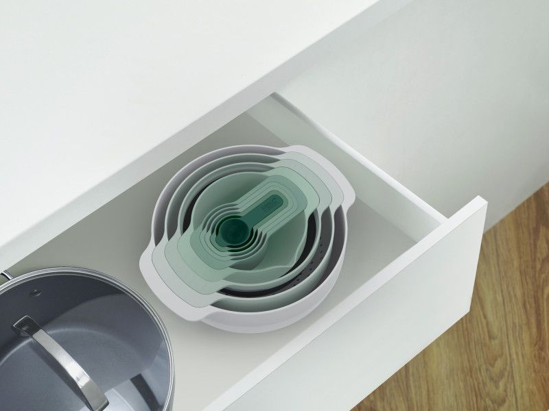 Joseph Joseph Nest 9-piece bowl set in sage green, featuring nesting design, mixing bowls, colander, sieve, and measuring cups.