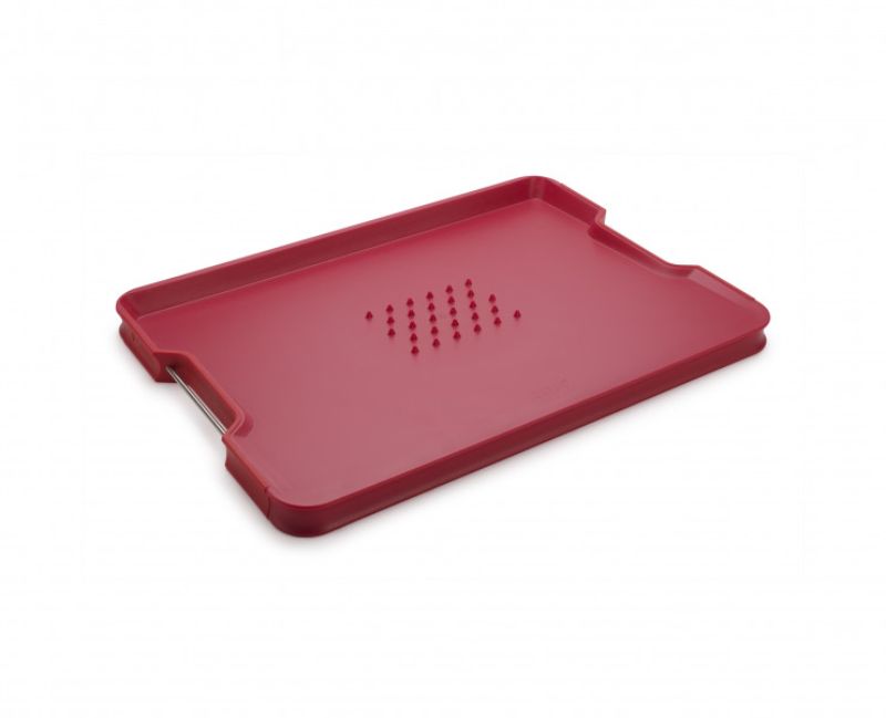 Joseph Joseph Cut & Carve Plus Large Red chopping board, features dual sides, angled base, and non-slip edges for stability.