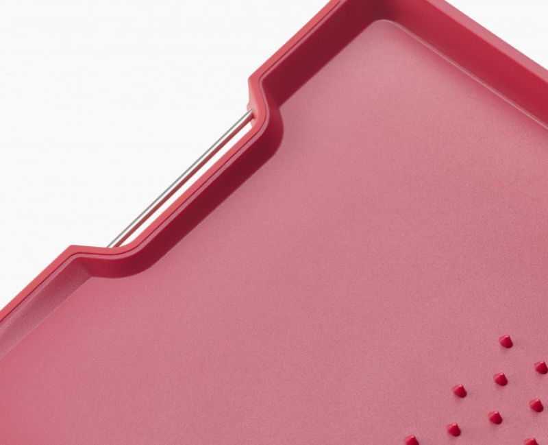 Joseph Joseph Cut & Carve Plus Large Red chopping board with angled base, non-slip edges, and integrated meat grip for easy carving.
