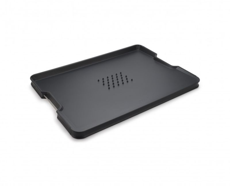 Joseph Joseph Cut & Carve Plus XL Black chopping board with angled base, integrated meat grip, and easy-pour corners for mess-free use.