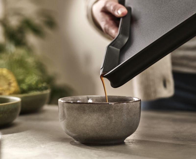 Joseph Joseph Cut & Carve Plus XL Black chopping board with angled base for easy crumb and juice capture, meat grip, and non-slip edges.