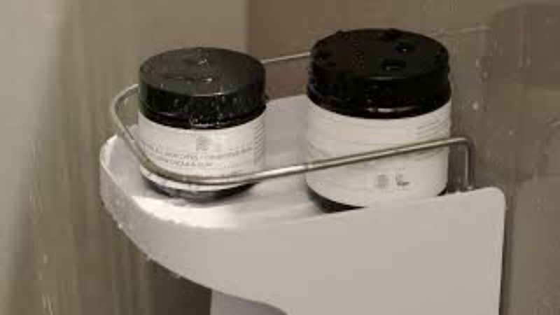 Joseph Joseph Capsule Compact 2-Tier Shower Shelf with self-draining top, stainless-steel rail, and hooks for organizing essentials.