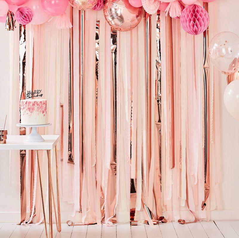 Pink and rose gold streamer backdrop with pastel balloons, perfect for festive celebrations and photo booths.
