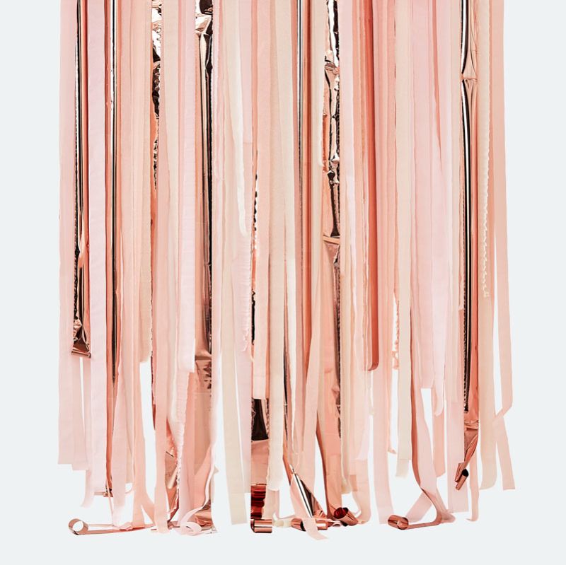 Pink and rose gold streamer backdrop featuring vibrant crepe paper and balloons, perfect for festive celebrations.