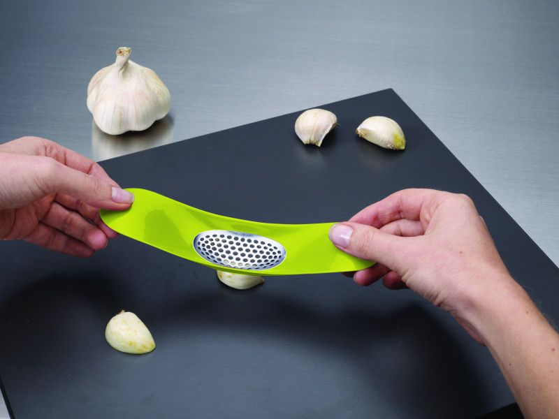 Joseph Joseph Garlic Rocker in green, a stylish tool for easily crushing garlic cloves with a unique rocking motion.