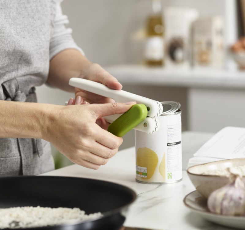 Joseph Joseph Pivot 3-in-1 Can Opener in white and green, featuring a can opener, bottle cap opener, and ring-pull lifter.