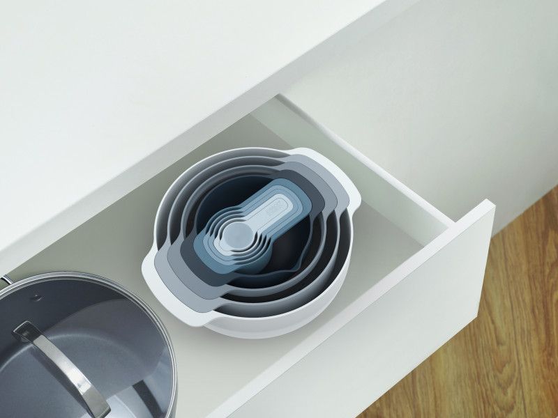 Joseph Joseph Nest 9 Plus food prep set in sky blue with nesting design, includes mixing bowls, colander, sieve, and measuring cups.