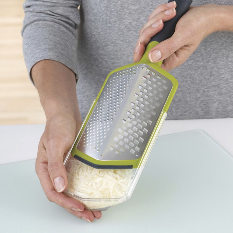 Joseph Joseph Twist Grater in green with coarse and fine blades, ergonomic handle, and detachable sheath for easy grating.