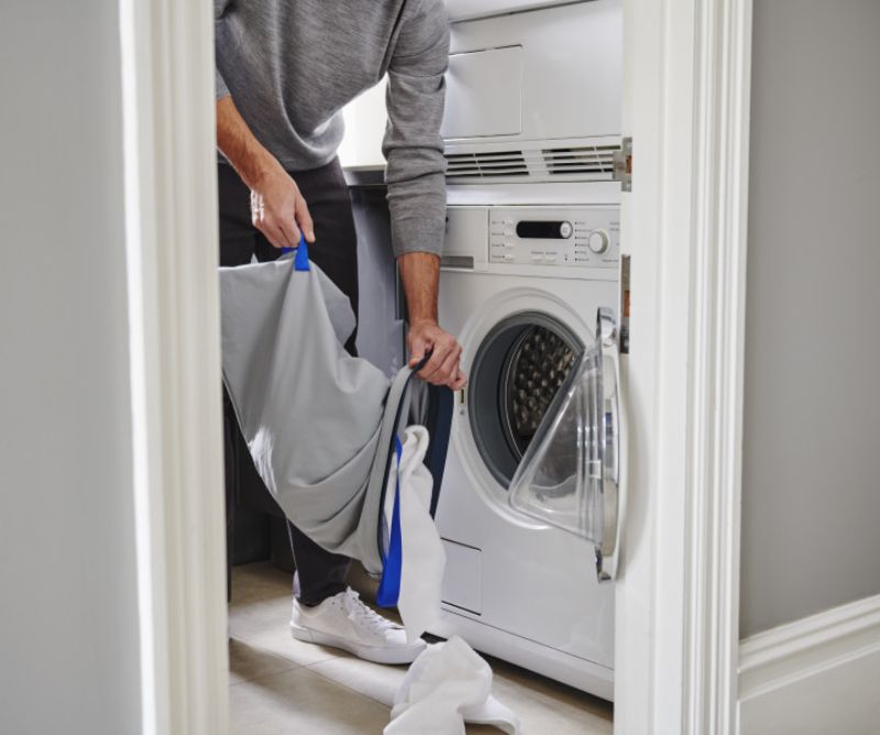 Joseph Joseph Tota 60-litre laundry basket with dual compartments for separating lights and darks in stylish carbon black.