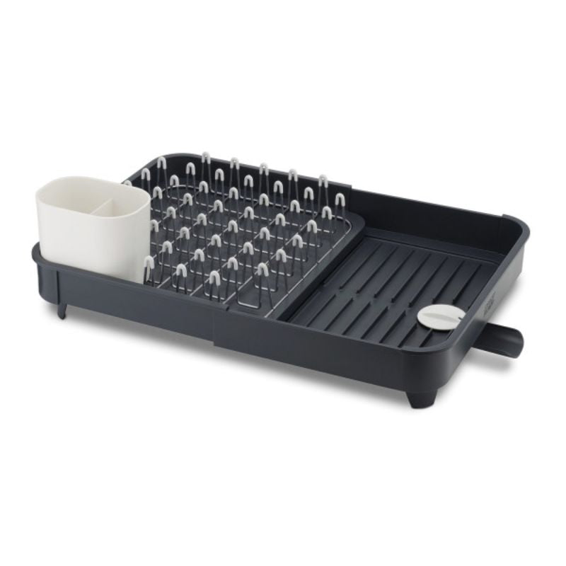Expandable grey dish rack with integrated spout, non-slip feet, and moveable cutlery drainer for efficient dish drying.