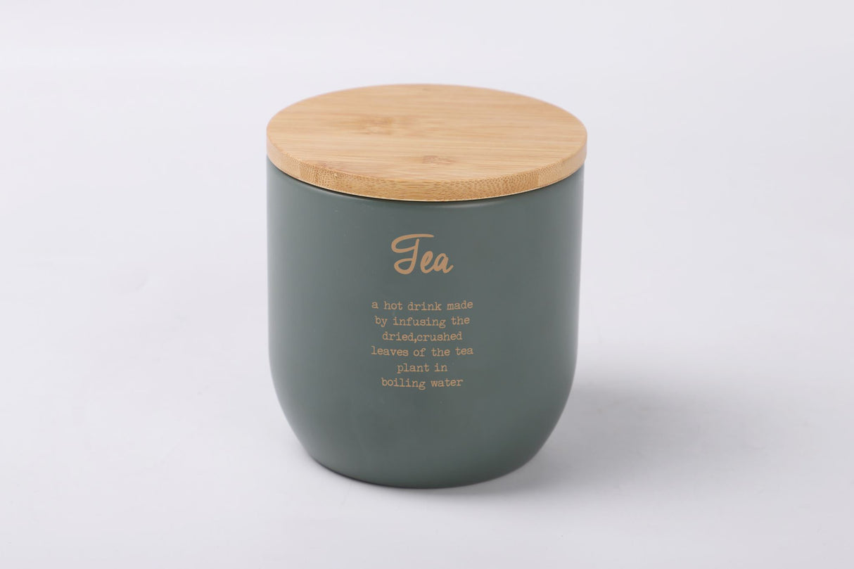 Rockingham Tea Tin: Stylish gray-green metal storage with gold lettering, bamboo lid, and rubber seal for freshness.