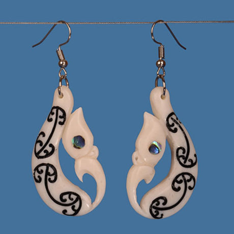 Handcrafted Manaia Earrings featuring carved beef bone, black kowhaiwhai patterns, and paua eyes, symbolizing protection and elegance.