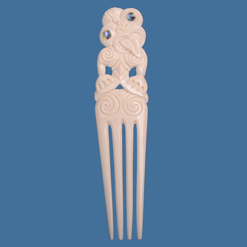 Large Bone Heru pendant with intricate Tiki design and unique paua inlays, symbolizing M?ori cultural heritage.