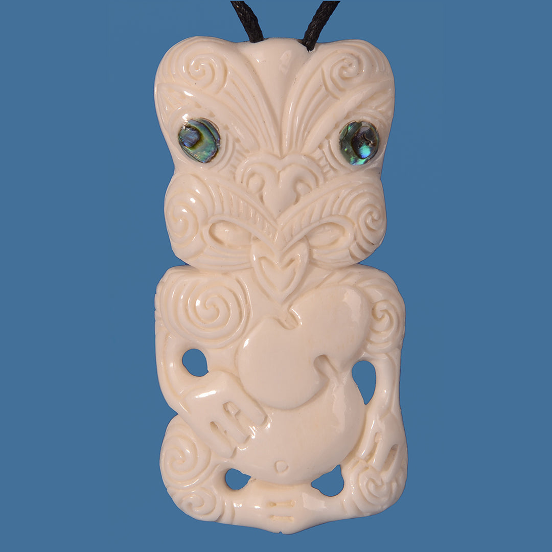 Handcrafted Bone Tiki pendant with Patu on adjustable black cord, featuring Paua shell eyes, symbolizing strength and heritage.