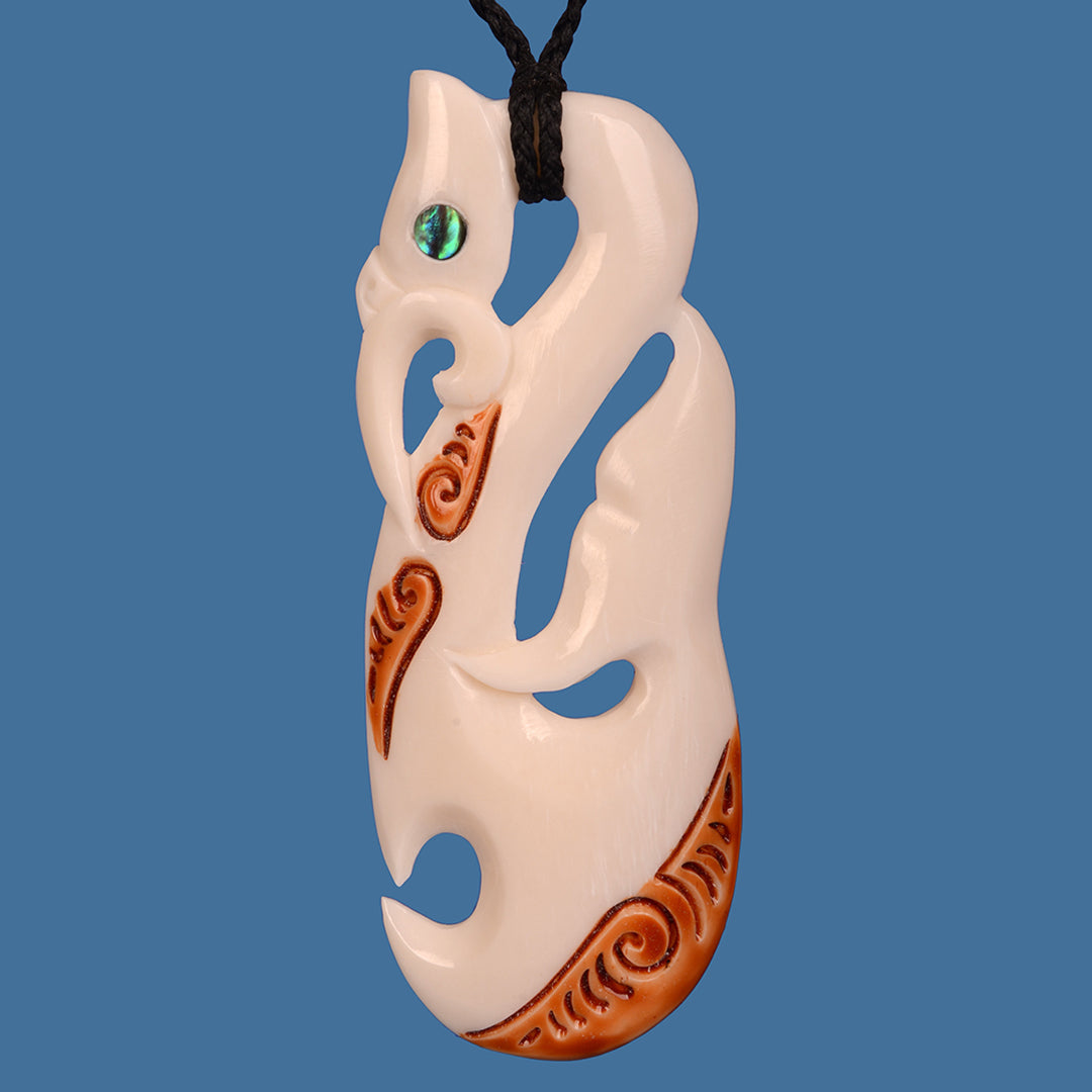 Intricately carved Bone Manaia pendant with Whale Tail design, showcasing Maori artistry and a unique stained finish.