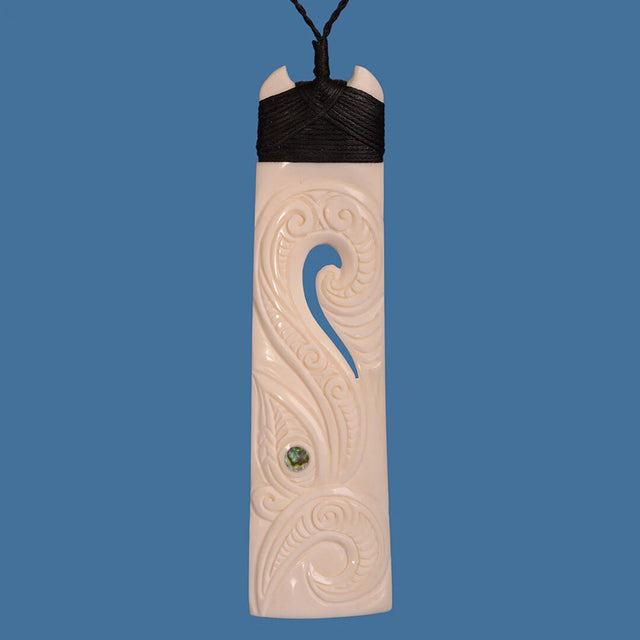 Bone Toki pendant with Manaia design, blending Maori culture with modern elegance on a black adjustable cord.