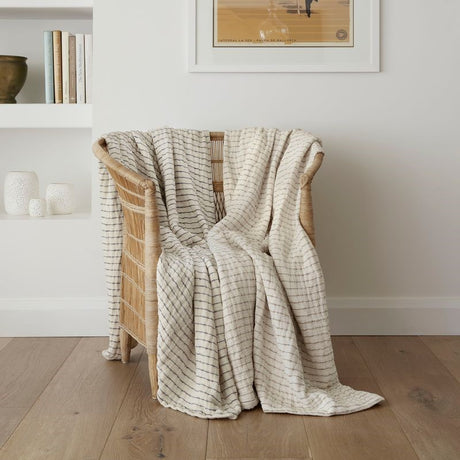 Lightweight ecru and charcoal reversible throw blanket with vertical stripes, perfect for cozying up or enhancing decor.