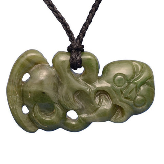 Medium-sized hand-carved Nephrite Jade Tiki pendant on braided black cord, symbolizing good luck and Maori heritage.