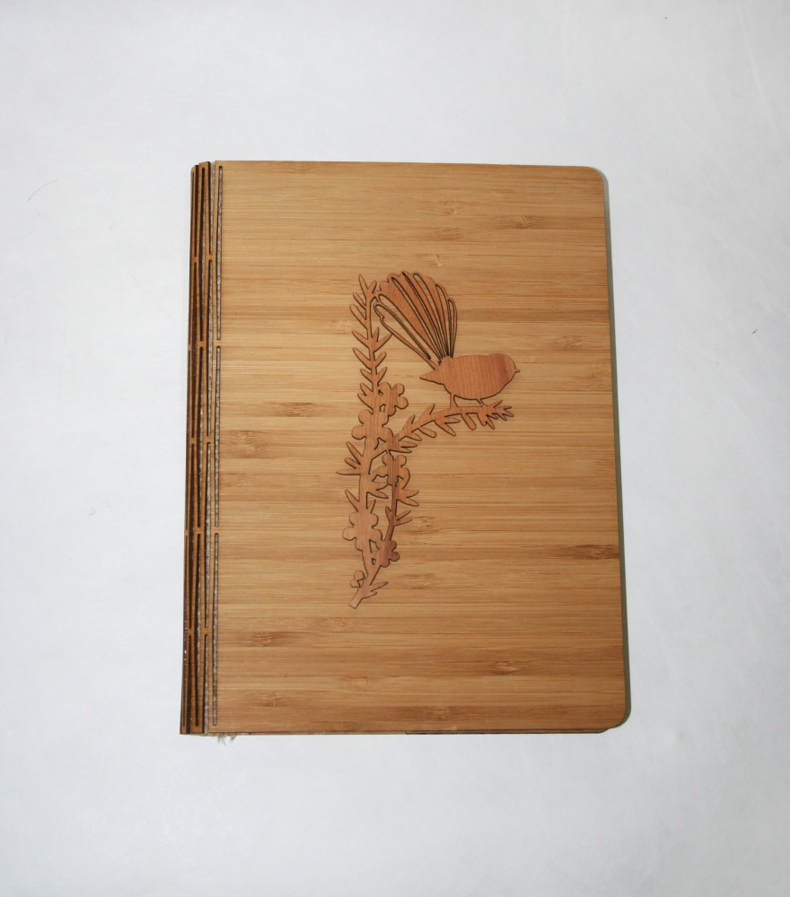 Elegant NZ Silver Beech notebook with bamboo veneer, featuring a fantail motif on a tall manuka pattern, perfect for journaling.