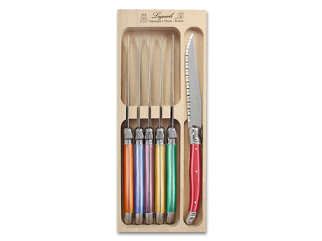 Set of 6 André Verdier steak knives with vibrant resin handles and stainless steel blades, presented in a wooden tray.