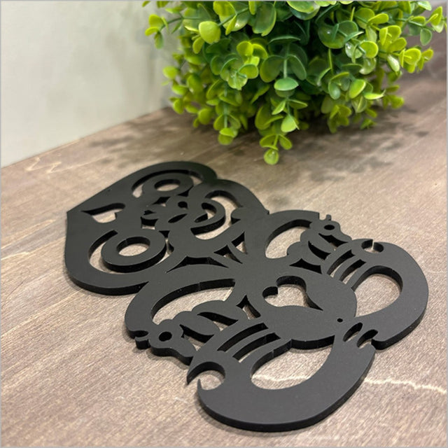 Sleek black acrylic wall art featuring Hei Tiki design, ideal for modern decor or unique bedroom accents.