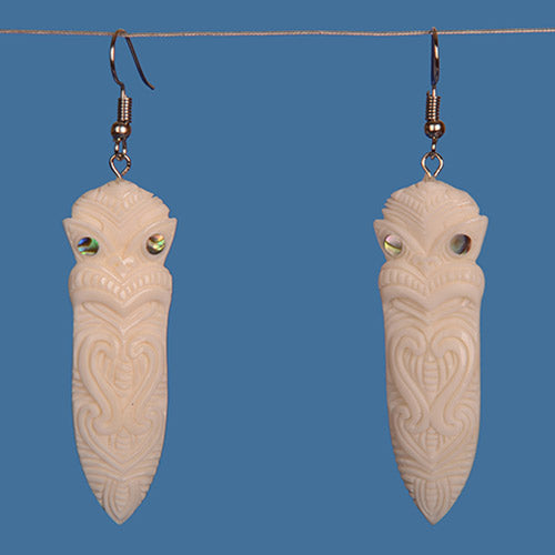 Handcrafted Bone Tiki Earrings with paua shell accents, representing Maori culture and unique artisan craftsmanship.