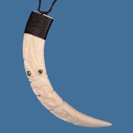 Tiki Silhouette Pig Tusk Pendant with Paua shell inlays on braided cord, symbolizing protection and showcasing M?ori craftsmanship.