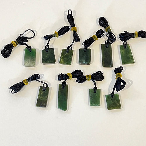 10 unique Greenstone Offcut Pendants showcasing Maori artistry, made of genuine Nephrite Jade on braided black wax cords.