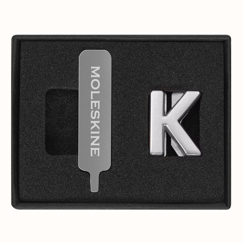 Stylish Moleskine Pins K Silver for personalizing notebooks with initials, quotes, and dates, made from durable zinc alloy.