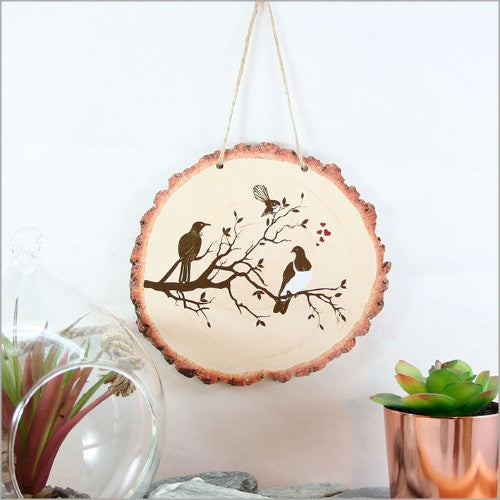 Wood slice wall art featuring vibrant birds perched on a tree, elegantly designed for nature lovers.