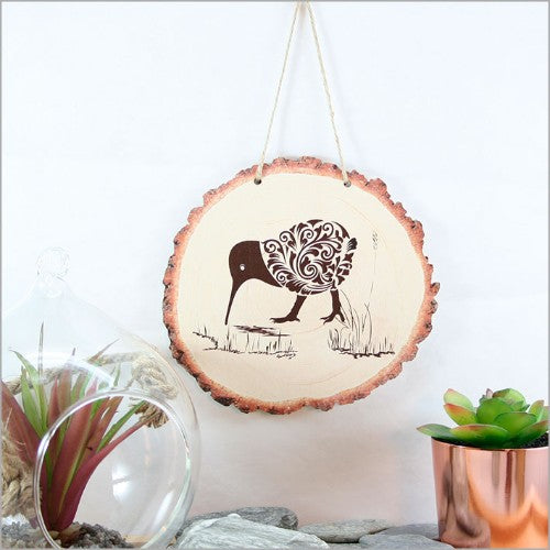 Exquisite wood slice wall art featuring a filigree kiwi design, celebrating culture and nature, ready to hang.