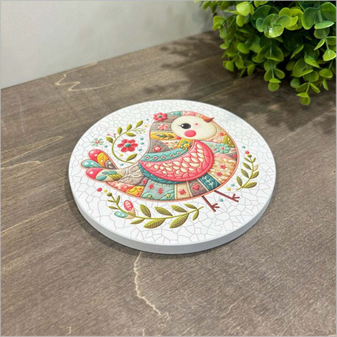 Canvas circle featuring a pink patchwork bird design, perfect for brightening home decor in small spaces.