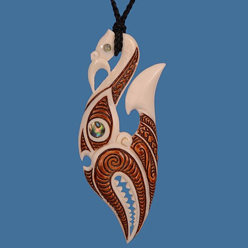 Intricate Manaia Hook Pendant Necklace featuring detailed carvings and vibrant P?ua shell inlay on an adjustable cord.