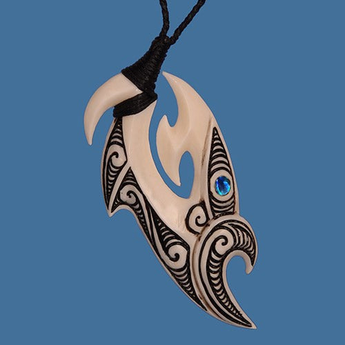 Handcrafted M?ori bone carving necklace featuring a unique Manaia hook and colorful P?ua shell eye, symbolizing protection and good fortune.