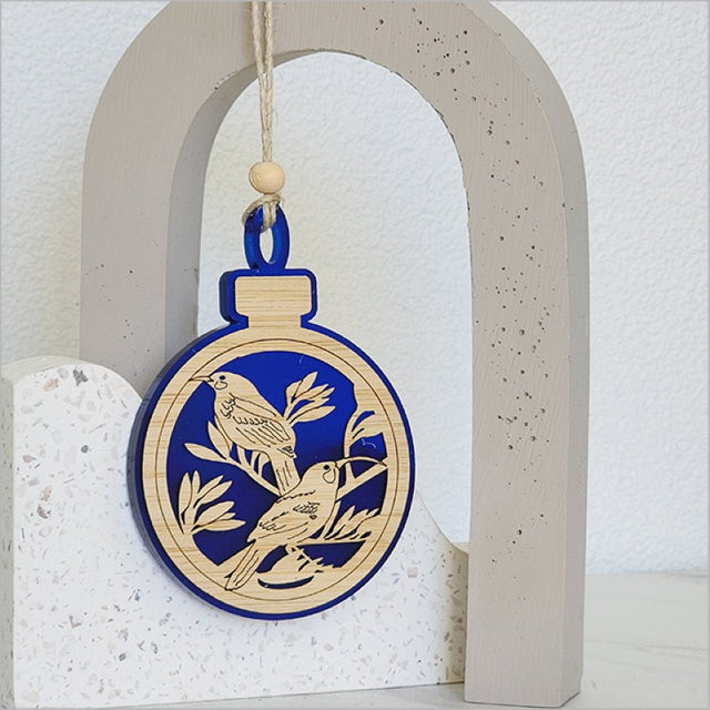 Elegant blue satin acrylic bauble featuring a Huia bird design, perfect for festive decor or gifting.