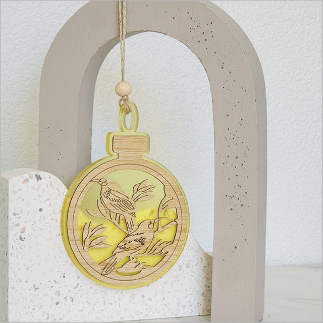Vibrant yellow acrylic bauble ornament featuring detailed Huia design, perfect for festive decorating or gifting.