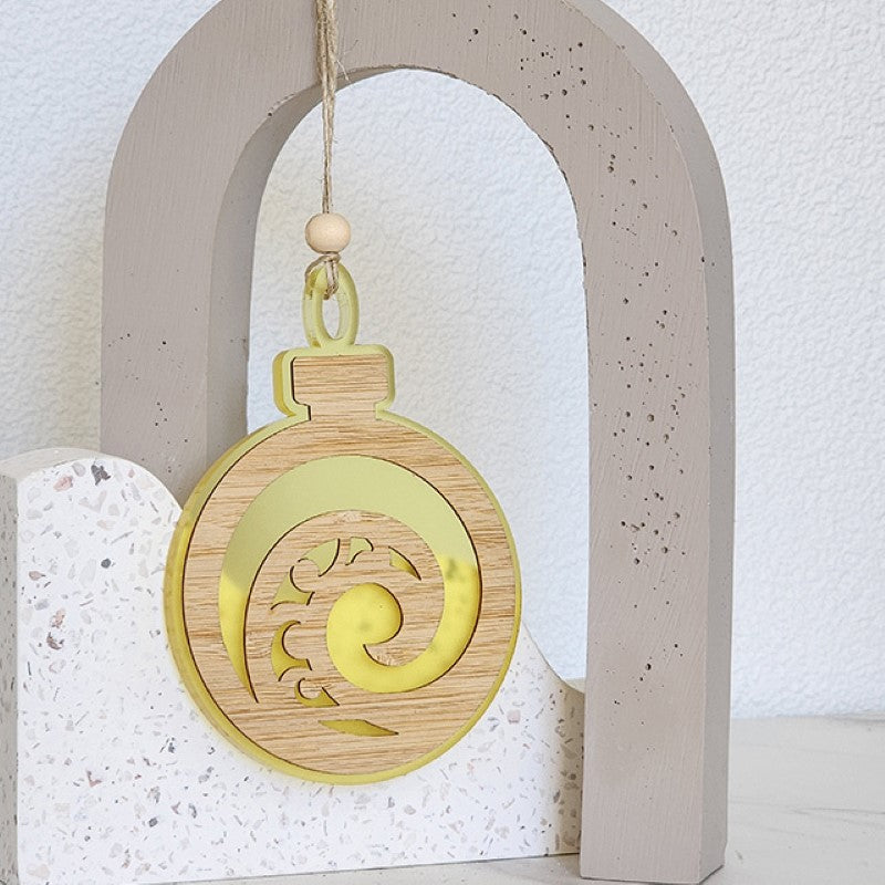 Yellow satin acrylic hanging ornament featuring a unique Koru design, perfect for home decor and festive occasions.