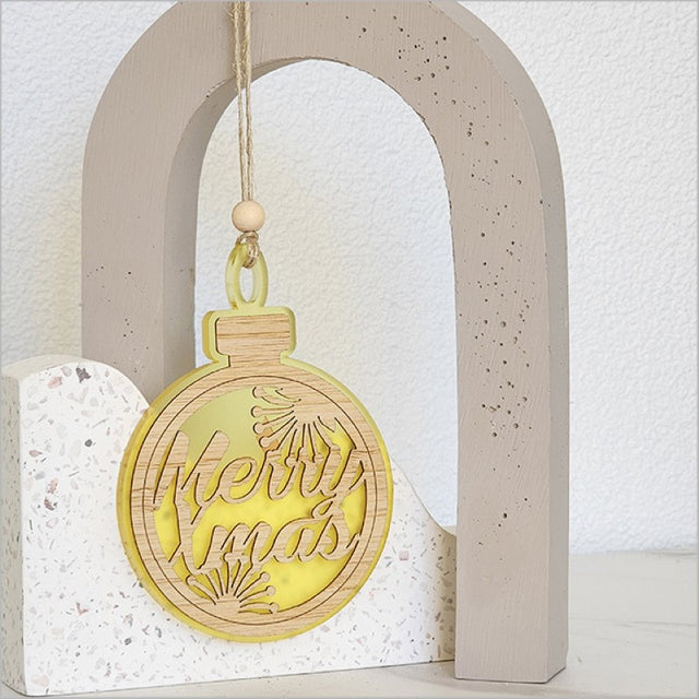 Bright yellow acrylic bauble ornament featuring 'Merry Xmas', perfect for holiday decor and gifting.