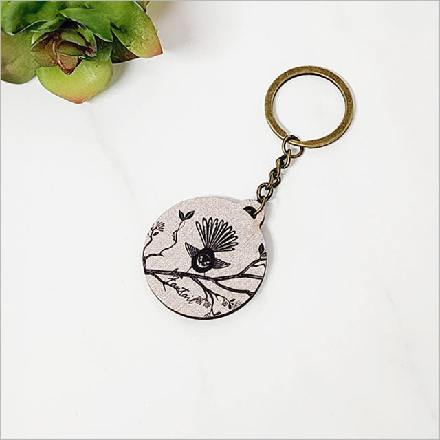 Lightweight printed pine keychain featuring a charming Fantail design, perfect for showcasing Kiwiana style.