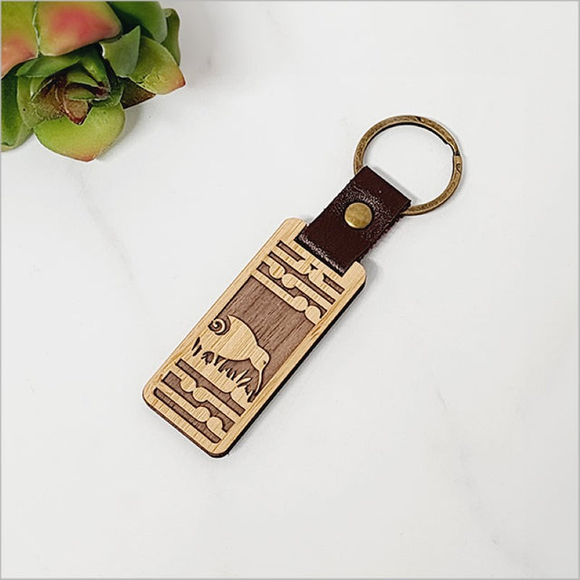 Eco-friendly bamboo keyring featuring a Kiwi and Koru design, perfect for adding Kiwiana style to your keys.