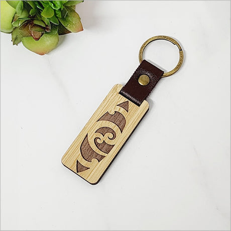 Elegant bamboo keyring showcasing intricate laser-cut design, eco-friendly and lightweight, perfect for everyday use.