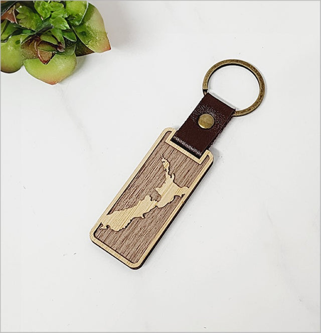 Eco-friendly bamboo keyring featuring a detailed New Zealand map, perfect for nature lovers and organized key storage.