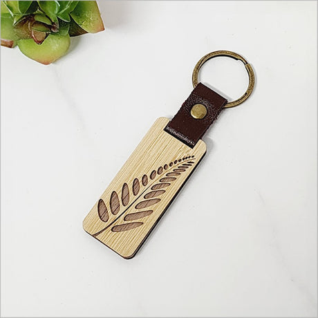 Lightweight bamboo keyring with solid fern design, ideal for everyday use and gifts.