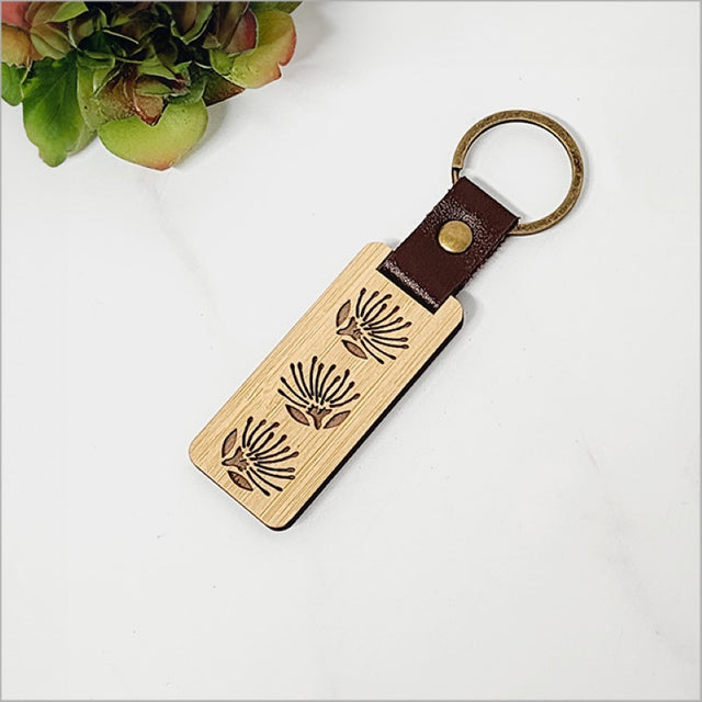 Eco-friendly bamboo keyring featuring intricate pohutukawa design, perfect for Kiwiana lovers and everyday use.
