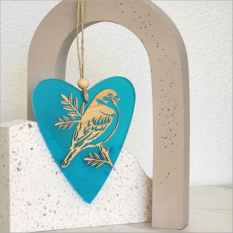 Teal satin acrylic heart ornament featuring sparrow and pihoihoi designs, perfect for home decor and gift giving.